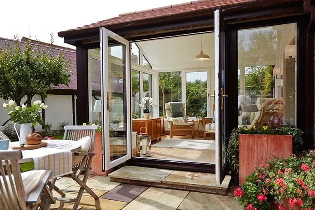 Dual dark woodgrain French doors on traditional tile extension