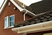 White uPVC guttering and downpipes and a gable end bargeboard from the Anglian rooftrim range