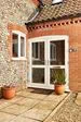 Cream uPVC French front doors with clear fully glazed glass chrome handle and letterbox exterior view from the Anglian French door range