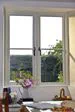 Timber cottage window finished in White with centre mullion and black window handles from Anglian Home Improvements