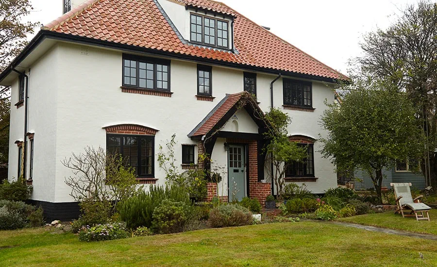 Black timber double glazed casement windows and wooden front door with georgian bars from the Anglian wooden windows and doors range