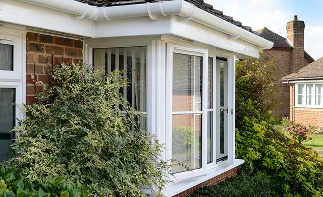 Close up of White uPVC guttering and fascia over bungalow bay window from the Anglian rooftrim range